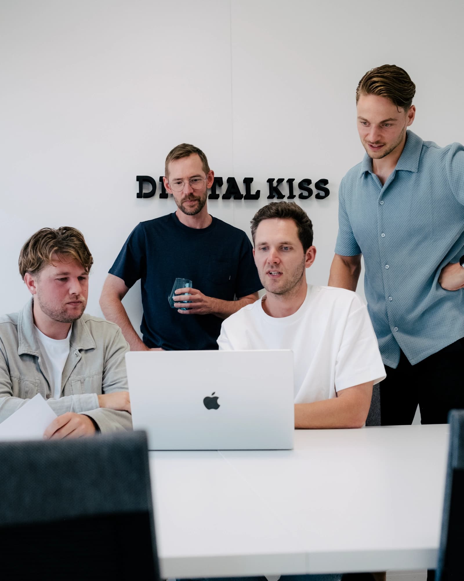 Het team van Digital KISS kijkt naar een presentatie op de laptop van Iwan