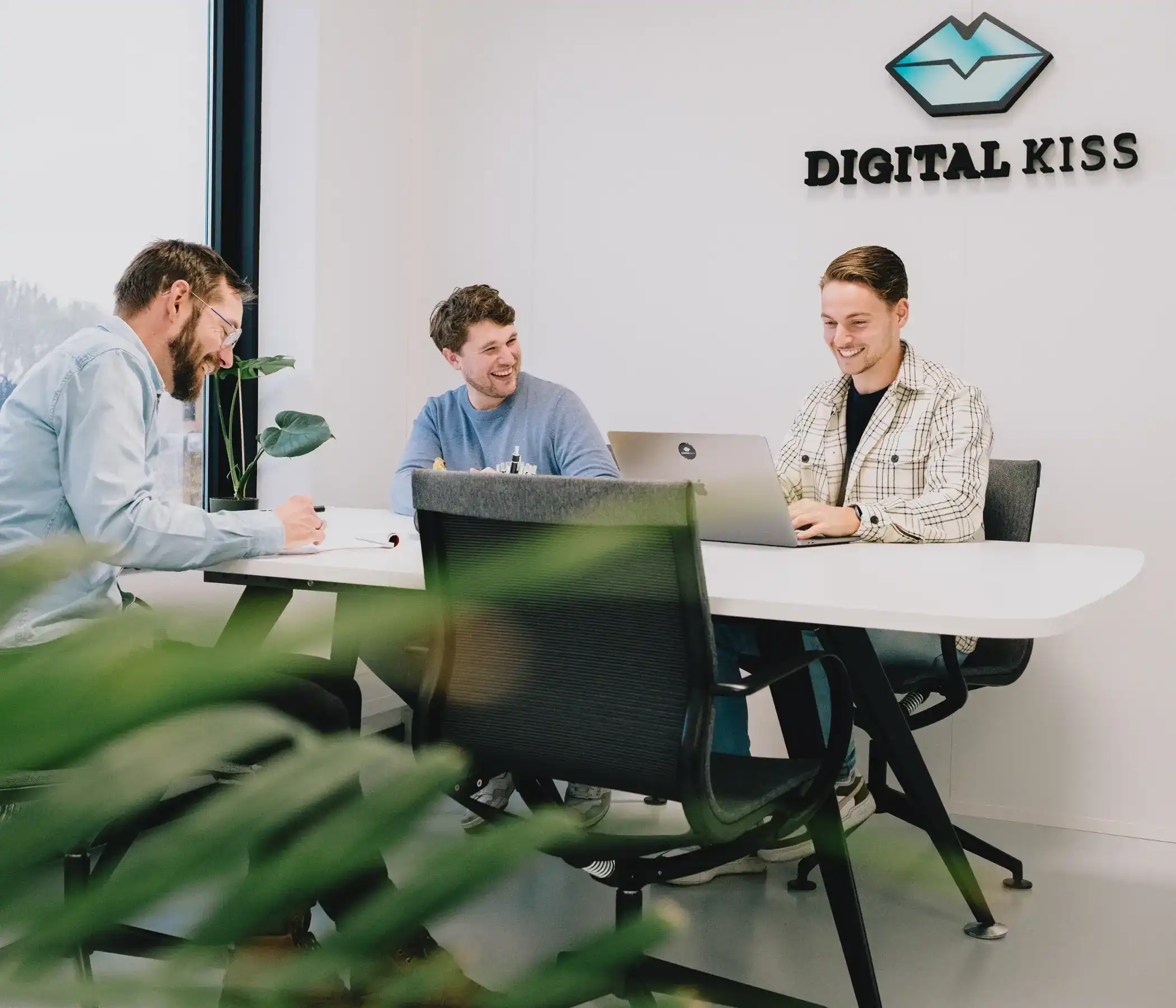 Sam, Leendert en Joost zitten aan de vergadertafel in overleg over een project